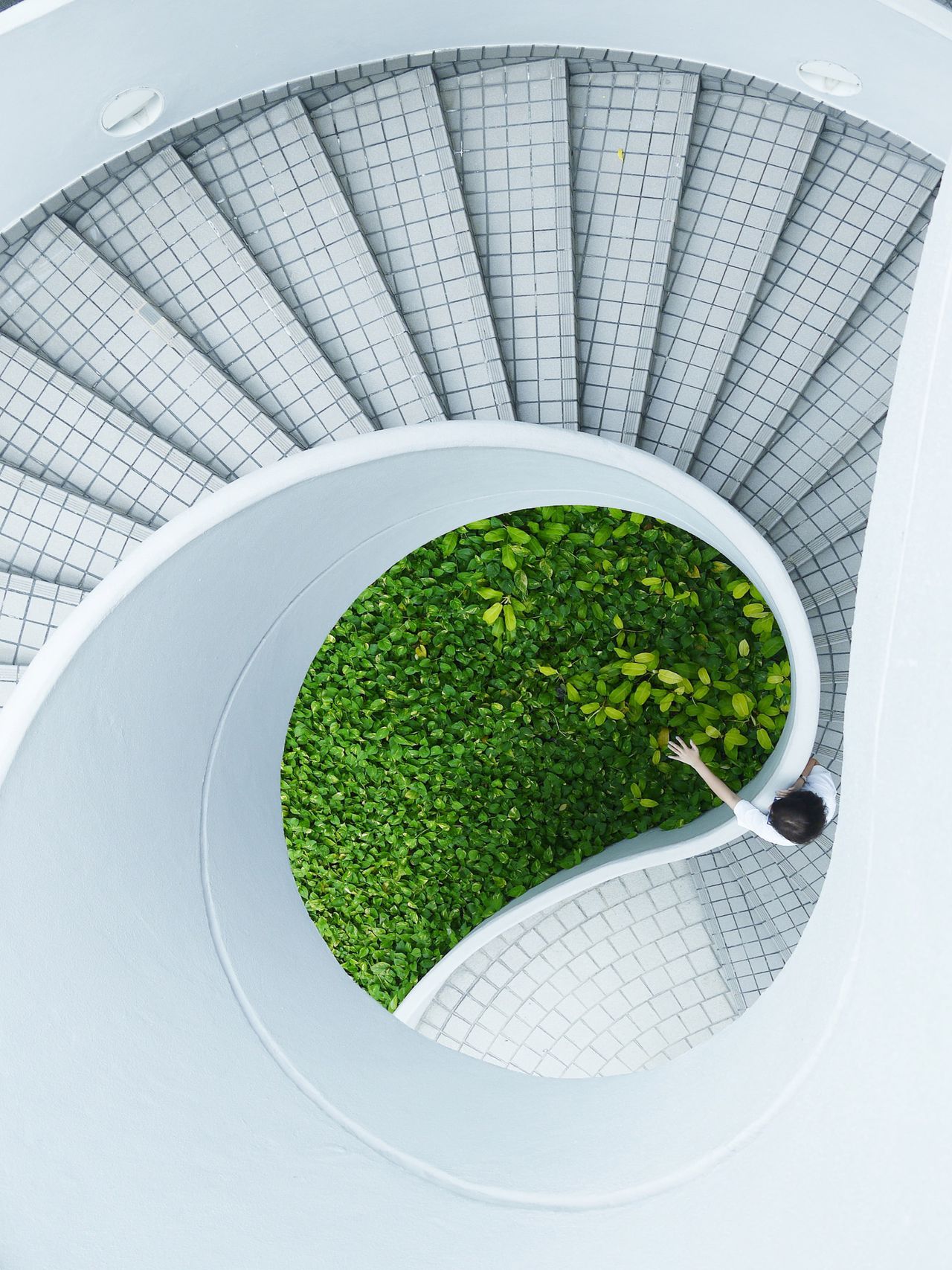 Woman standing on spiral stairs (Danist Soh)